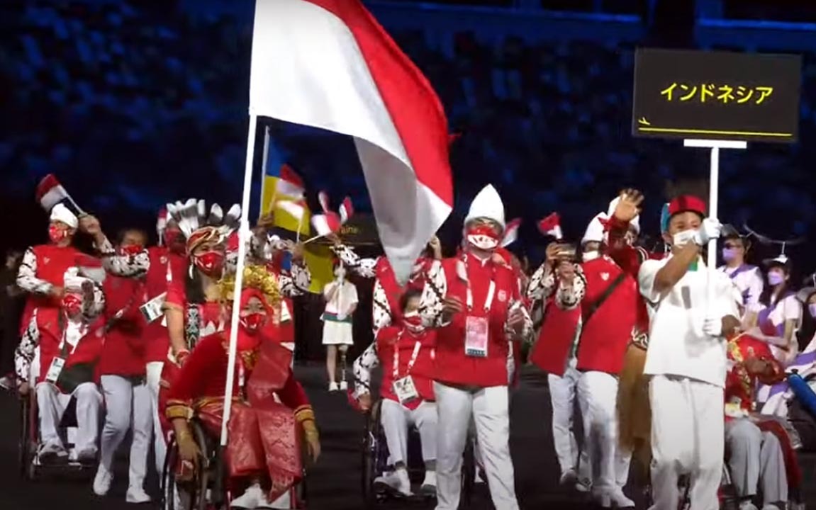 Kontingen Indonesia mengenakan baju tradisional saat defile dalam upacara pembukaan Paralimpiade Tokyo 2020 di Olympic Stadium, Selasa (24/8). Kostum tersebut dimodifikasi dari sejumlah baju tradisional dari budaya Sumatera, Bali, Kalimantan dan Papua. Se